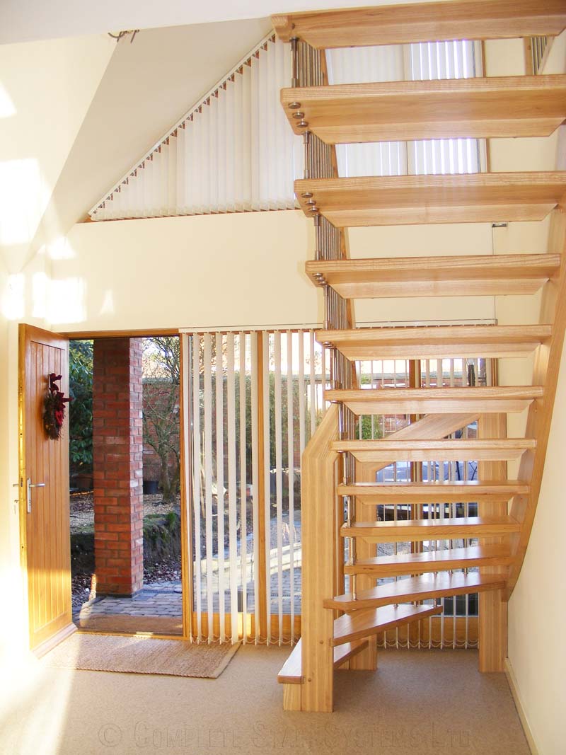 Bespoke Timber Staircase Coventry front door and window in house with carpeted floor with floating staircase