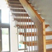 straight flight stair with open risers and an oak handrail