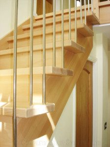 close up to side of wooden staircase with closed riser and cut stringer