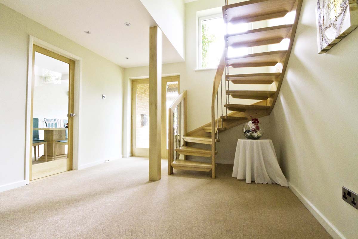 Bespoke Timber Staircase Tadley carpeted hallway with wooden floating stair twisting upstairs