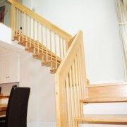 timber open plan staircase with black chairs below