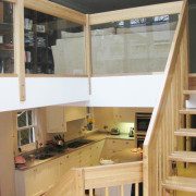 glass panels around the edge of a mezzanine floor with kitchen below