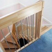 section of landing balustrade at the top of a stairwell with blue carpet behind