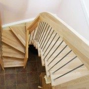 looking down a stairwell with a light timber staircase