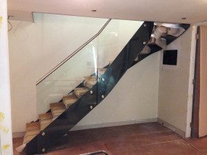 side view of black steel stair being installed on a building site