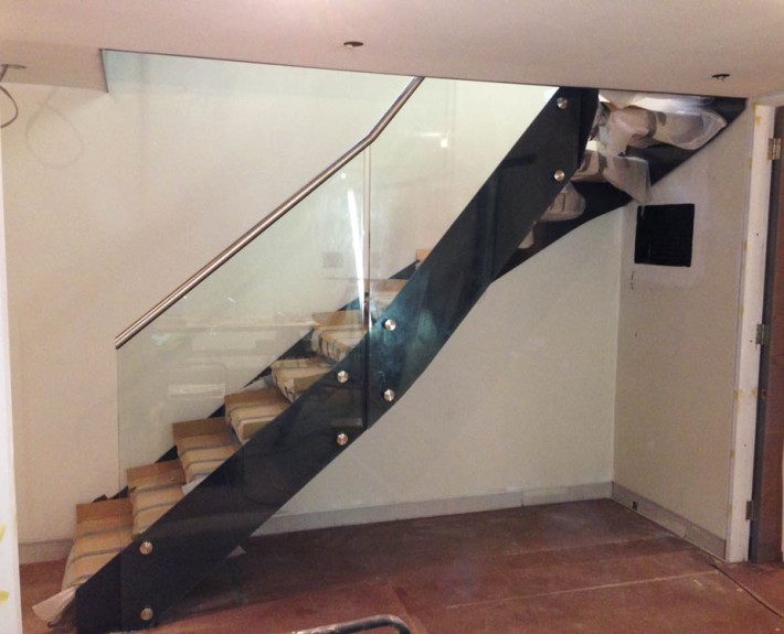 side view of black steel stair being installed on a building site