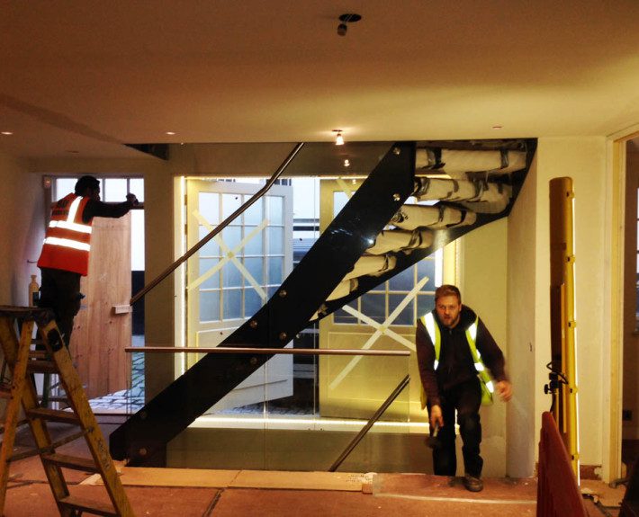 men installing a steel staircase on a building site