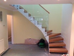 white zig zag steel staircase with frameless glass panels
