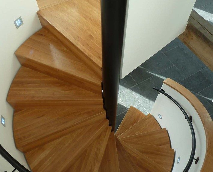 looking down on a oak tread spiral staircase with a black centre column