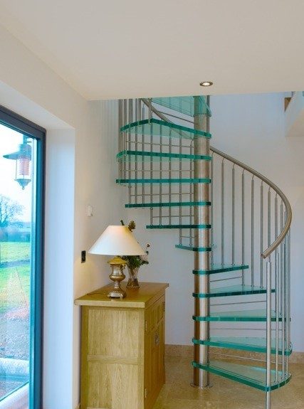 glass spiral stair alongside an oak sideboard
