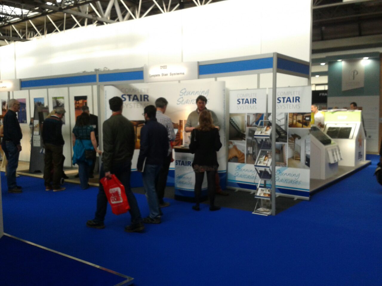 exhibition stand with blue carpet with people