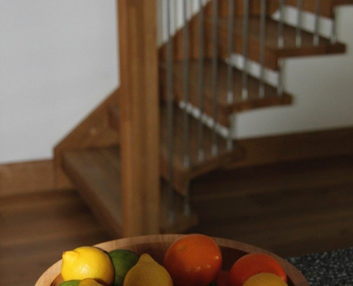 bowel of fruit with floating style wooden stair behind