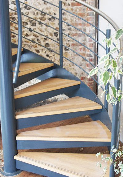 Commercial Spiral Staircase - Wickham, Hampshire 4 oak steps on a steel spiral staircase with a stone wall behind