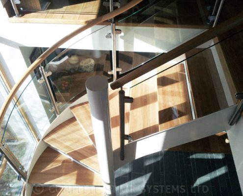 oak treads on a spiral staircase with glass panels