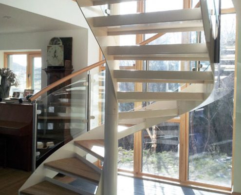 white steel staircase in front of a large window with oak treads