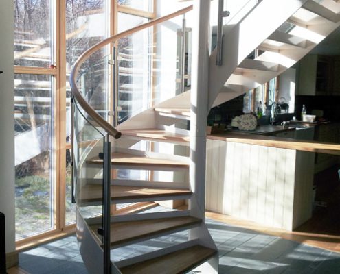 large white steel spiral staircase in front of a large window