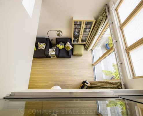 looking down on a carpeted hallway with frameless glass
