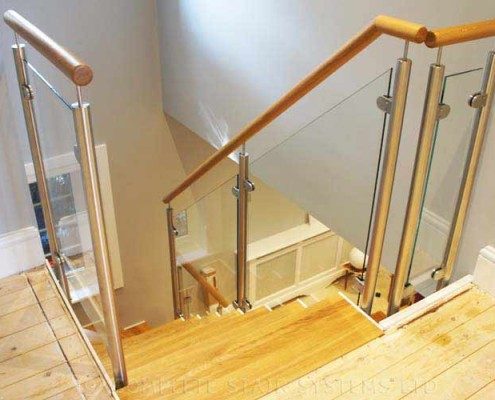 oak steps on a glass staircase with a timber handrail
