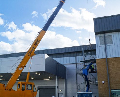 crane lifting part of a spiral staircase