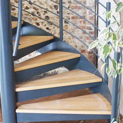 bottom oak steps of a spiral stair with stainless handrail
