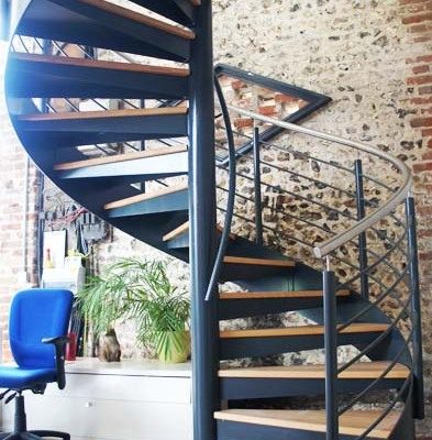 dark blue stringer on a spiral staircase with stainless handrail with a timber floor below