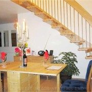 dining table with candle stick with floating timber staircase behind