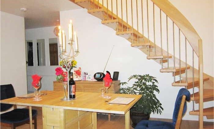 dining table with candle stick with floating timber staircase behind