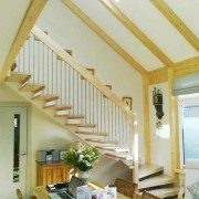 living space with floating timber staircase running up a wall