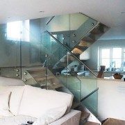 glass balustrade on a steel staircase in living and kitchen area in a house