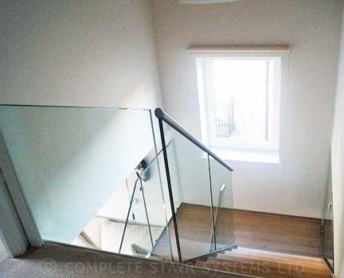 Modern-Staircase-London-3 looking down a half turn staircase with timber steps and glass balustrade