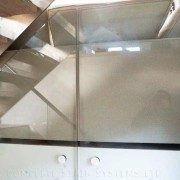 glass infill panel behind light grey sofa in home