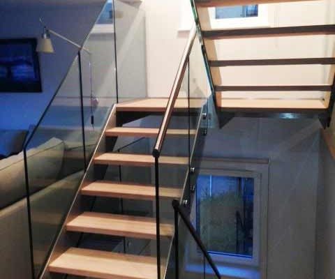 double flight staircase with open risers and glass balustrade