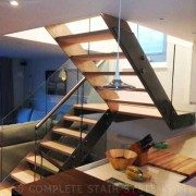 half turn wood , steel and glass stair with open risers with kitchen in foreground