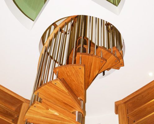 spiral stair leading up to a circular opening and glass floor above
