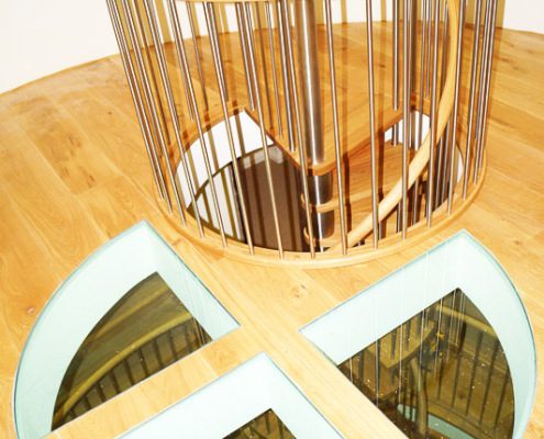 glass floor and circular hole in floor with spiral staircase