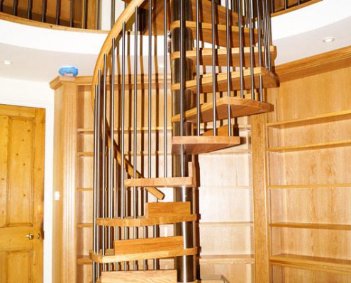 oak double flight spiral staircase leading up to a balcony