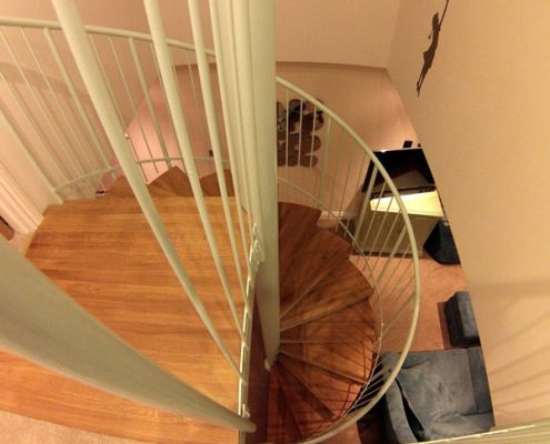 oak and white spiral stair with blue sofa