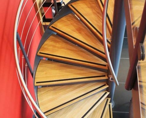 spiral stair with stainless steel handrail with red wall to side