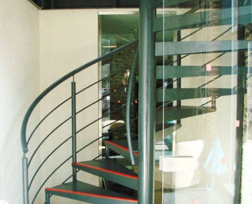 black painted spiral staircase with horizontal rails and glass panel