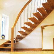 mirror leaning against a wall with floating timber staircase above