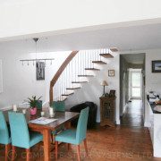 kitchen and dining area with open riser floating timber staircase ascending through stairwell