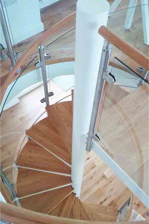 spiral stair with white centre column and stainless posts with curved glass