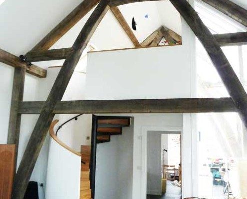 timber framed building with grey tiled floor showing a spiral staircase in oak