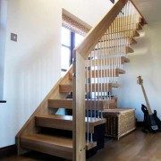 straight oak stair in a floating style with a white wall to one side and timber floor below