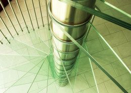 close up on glass step spiral staircase and stainless steel spindles
