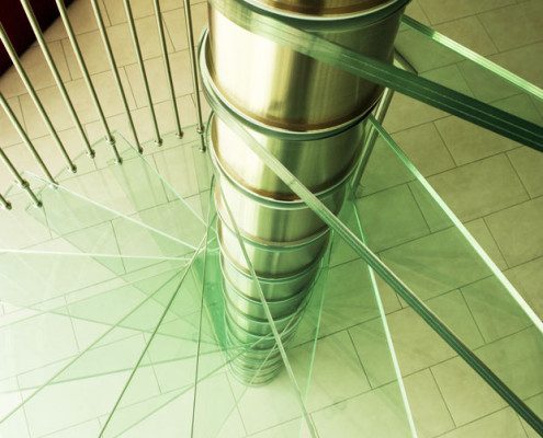 close up on glass step spiral staircase and stainless steel spindles