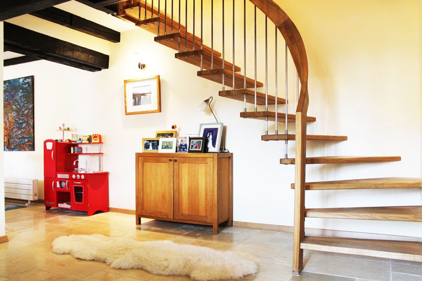 Curved oak handrail on a floating timber staircase next to a white wall