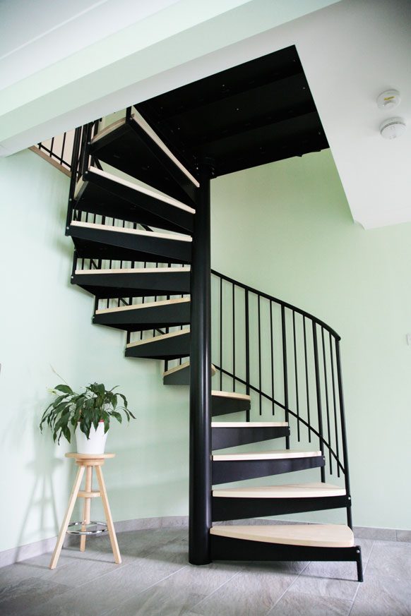 black spiral staircase with a green room behind