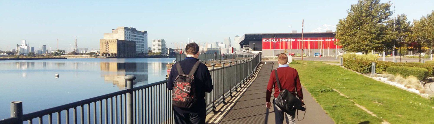 men walking along a river towards excel centre
