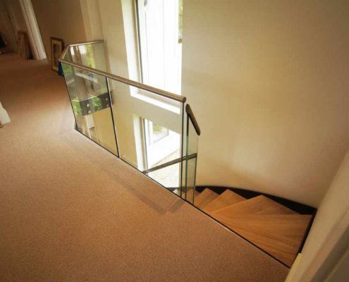 Bespoke-Staircase-Alresford-10 landing area in house with beige carpet and frameless glass